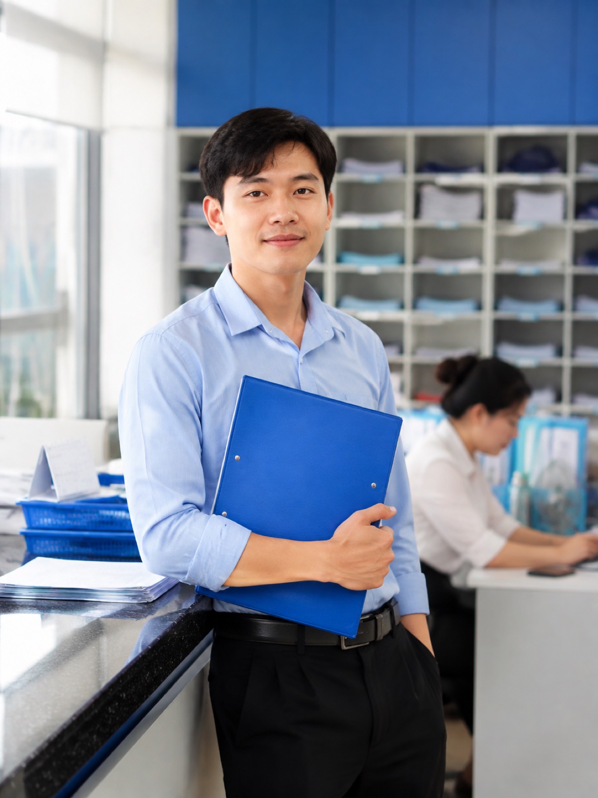 Nhân viên giao nhận trẻ đứng ở quầy chứng từ, tay ôm bìa hồ sơ