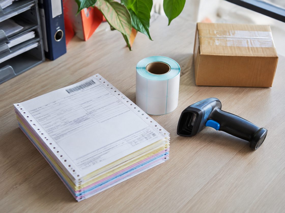 Xấp vận đơn và tem nhãn chuyển phát trên bàn