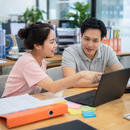 Học viên nam cầm laptop và sổ tay